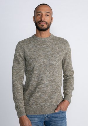 Light gray and beige knitted sweater, textured with a marled pattern, crew neckline, ribbed cuffs and hem, paired with blue jeans.