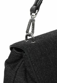 Borsa in tessuto nero con texture, dotata di hardware lucido in argento, caratterizzata da una forma elegante e un attacco per la maniglia in pelle nera.