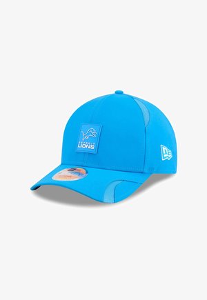 Blaues Cap aus Stoff mit Netzseitenteilen. Verfügt über ein quadratisches Detroit Lions-Logopatch auf der Vorderseite und eine markierte Seitenakzentuierung.