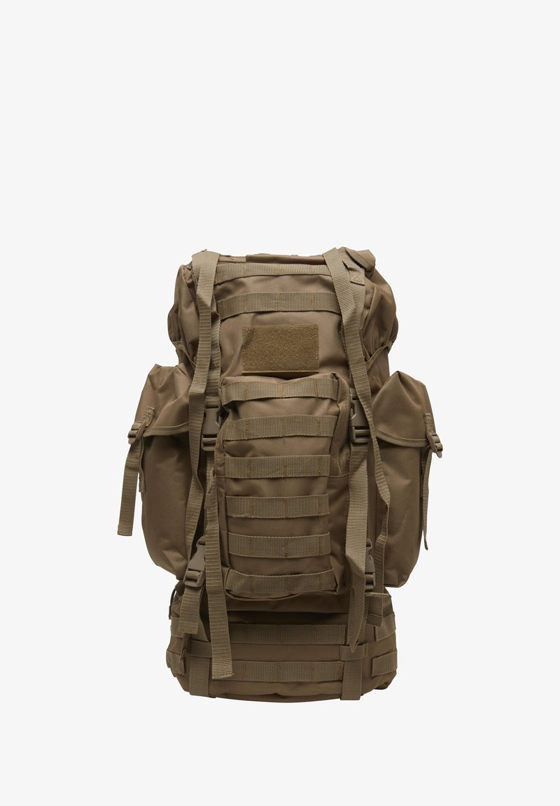 Grand sac à dos tactique marron avec plusieurs sangles, sections rembourrées, poches latérales et sangle MOLLE pour fixations modulaires.