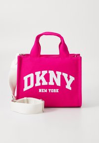 Roza torbica iz tkanine s kratkimi ročaji in snemljivim belim ramenskim trakom. Na sprednji strani je izstopajoč bel napis "DKNY NEW YORK".