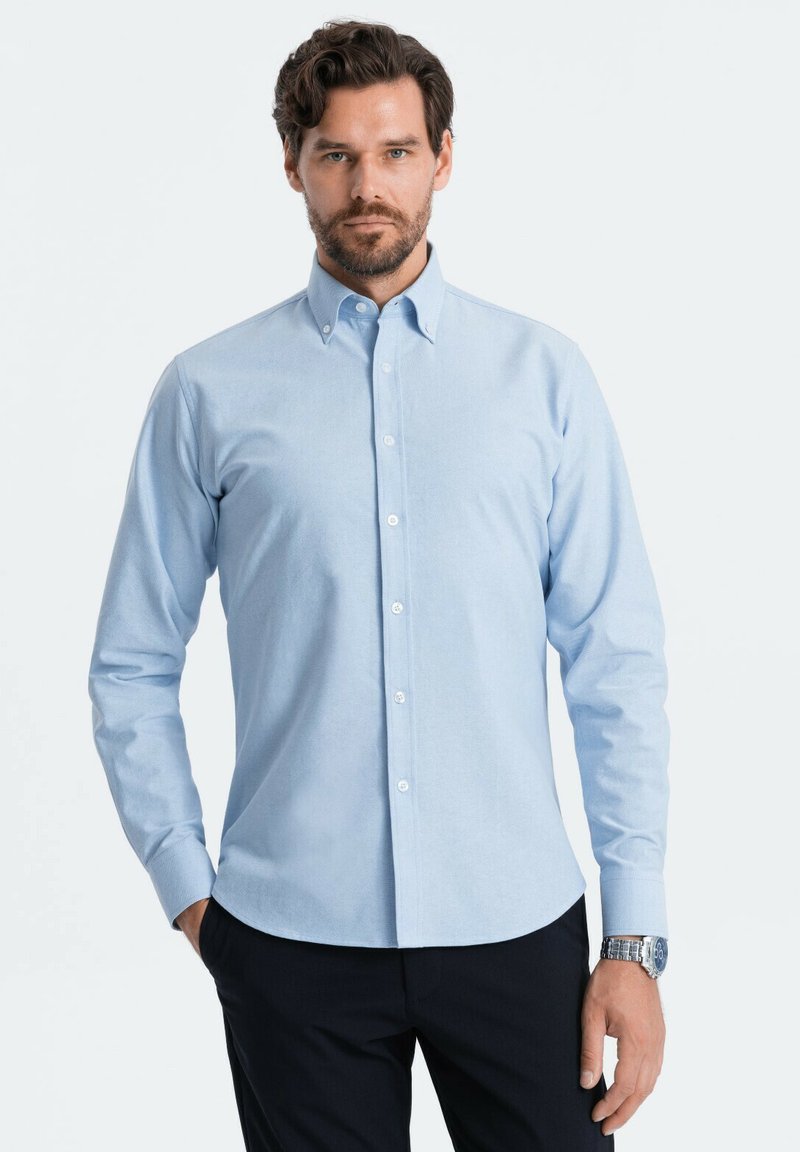 Lichtblauw overhemd met lange mouwen, knoopsluiting, een klassieke kraag en een rechte zoom. Voorzien van witte knopen en een gladde, textuurstof.