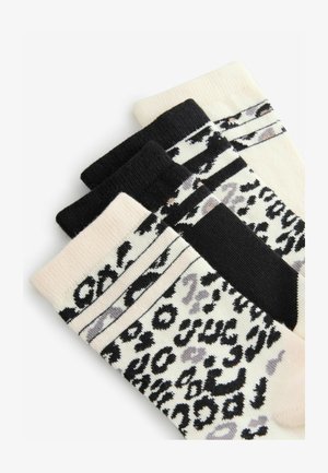Set de trei șosete care prezintă un amestec de culori: bej cu imprimeu leopard negru și gri, negru solid și negru cu dungi albe.