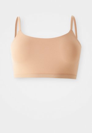 Lys beige bralette med tynde stropper, sømløs design, blødt stof og en glat tekstur. Ingen hardware eller udsmykninger synlige.