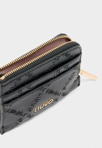Cartera de cuero negro con patrón texturizado, cremallera dorada y acento de logo. Cuenta con múltiples ranuras para tarjetas y un compartimento con cremallera.