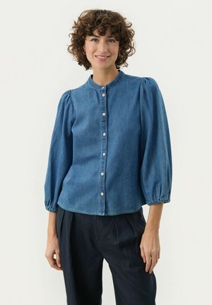 Denim blouse met een ronde kraag, knoopsluiting aan de voorkant en gatherings op de mouwen. Blauwe stof met een soepele textuur. Lichtjes cropped lengte.