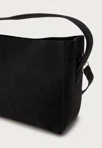 Sort læder skuldertaske med en glat overflade, rektangulær form og en enkelt justerbar rem. Har et minimalistisk design og rene linjer.