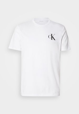 Witte katoenen t-shirt met korte mouwen, ronde halslijn en een zwart "ck" logo op de linkerborst. Eenvoudig, klassiek ontwerp.