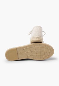 Scarpa slip-on beige con tomaia in tessuto testurizzato, lacci legati e suola in gomma con motivo a griglia. Taglia 31 marcata sul fondo.
