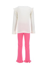 White long-sleeve top with ruffled accents, paired with pink leggings featuring flared cuffs and ruffle detailing at the hem.