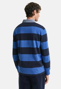 Mannen langsluiting polo shirt met horizontale strepen in marineblauw en blauw, een kraag halslijn en een relaxed fit. Katoenen materiaal.