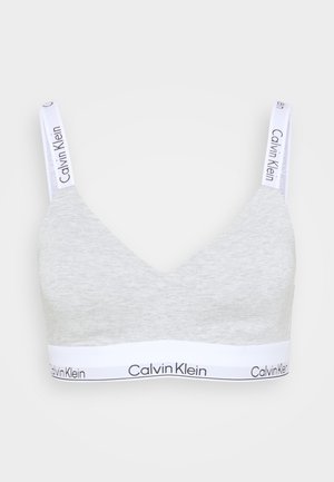Bralette en coton gris avec un décolleté en V et une large bande inférieure blanche portant un logo Calvin Klein noir. Bretelles blanches réglables.