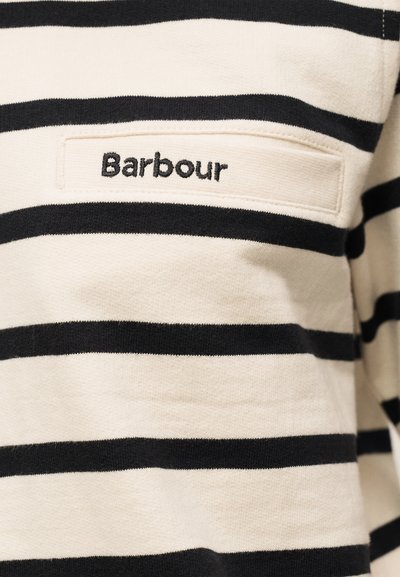 Tissu rayé horizontal crème et noir avec une poche plaquée rectangulaire cousue et "Barbour" brodé en fil noir.