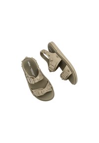 Sandalias beige con plantilla texturizada, dobles correas ajustables con hebillas cuadradas y acentos de tachuelas elevadas a lo largo de los lados.