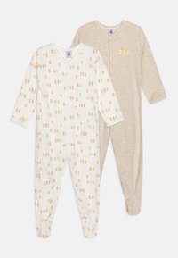 To baby jumpsuits: en i hvid med orange bamseprint og en i beige. Begge har lange ærmer og trykknaplukninger.