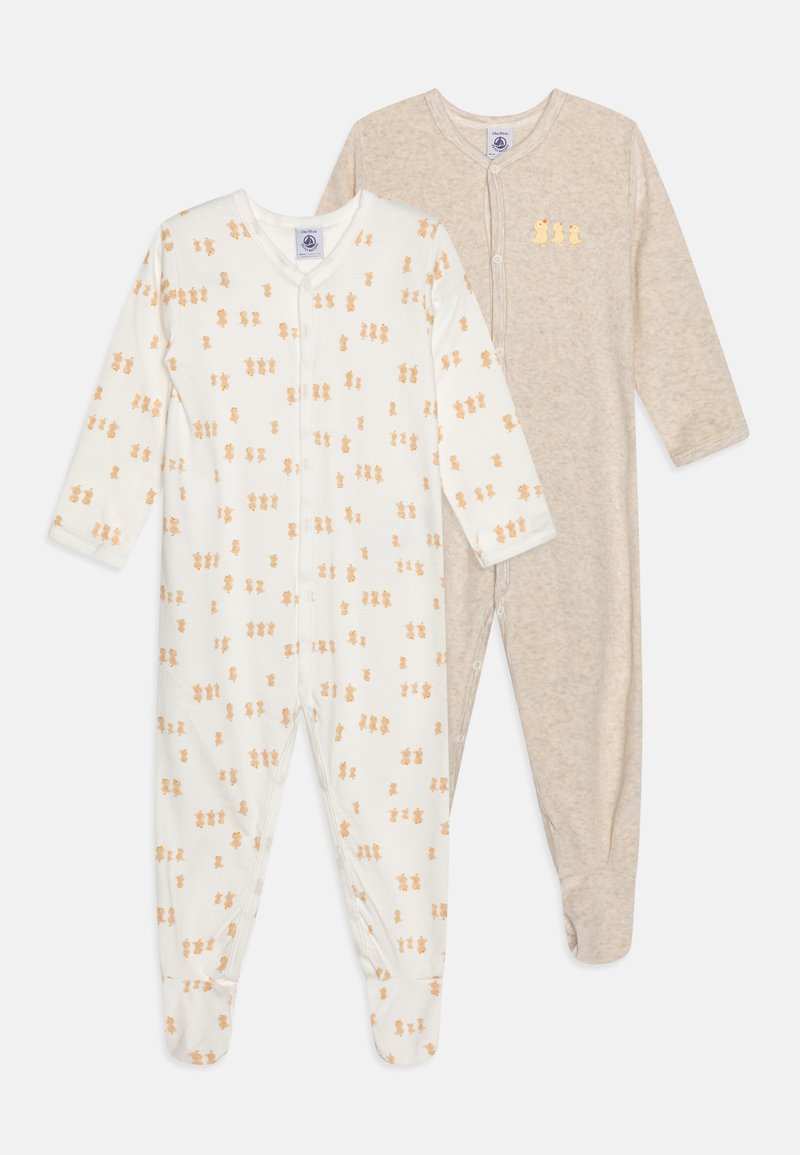 To baby jumpsuits: en i hvid med orange bamseprint og en i beige. Begge har lange ærmer og trykknaplukninger.