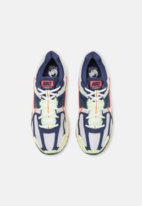 Tenisky Nike Vomero 5 v námořnické modři, bílé a neonově zelené. Síťovina a syntetický svršek s kulatou špičkou, polstrovaným límcem a živými akcenty.