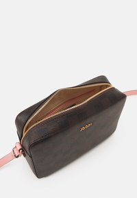 Sac à main rectangulaire en cuir texturé marron foncé avec une bandoulière rose. Doté d'une fermeture éclair dorée et d'une doublure intérieure dans une teinte plus claire.