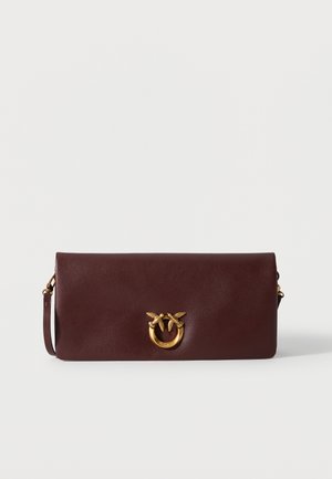 Pravokutna tamnobraon kožna torbica za ruke sa zlatnim okruglim kopčom s likovima dva ptice, i tankim remenom za nošenje preko ramena sa strane.