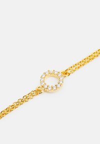 Guldarmband med runda länkar prytt med små klara stenar, som visar en texturerad design med sammanflätade kedjor.