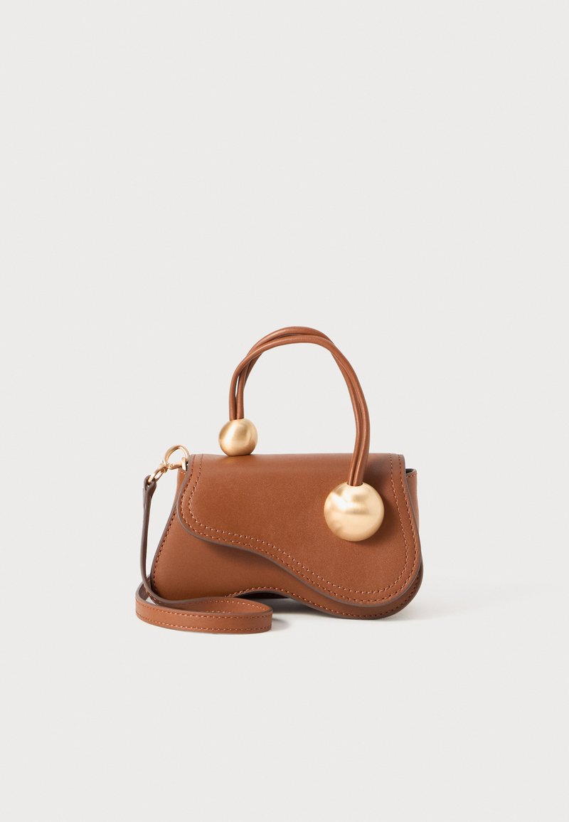 Sac à main en cuir marron avec un design ondulé, doté de deux accents dorés ronds et d'une bandoulière amovible pour un transport polyvalent.