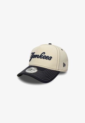 Casquette de baseball beige et noire réglable avec "Yankees" brodé sur le devant, logo New Era sur le côté et autocollant sur la visière.