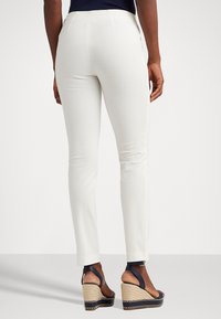 Vita skräddarsydda byxor med smal passform, midjehöjd, slätt tyg och raka ben. Bärs med marinblå kilklackar med en halmplattform.