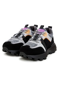 Paire de baskets noires, grises, violettes et beiges avec des lacets à motifs et des semelles épaisses et robustes sur fond blanc.