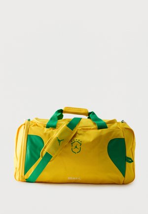 Žlto-zelená športová taška s nápisom "Brasil" a štítovým logom so hviezdami a siluetou jumpmana.