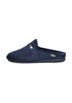 Zapatilla de felpa azul marino con punta redonda, parte trasera abierta y detalle de logo bordado en el lateral. Textura suave con suela de goma.