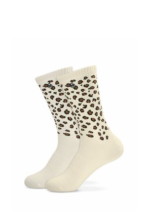Paire de chaussettes montantes couleur crème avec des taches léopard marron et noir et un petit logo noir près du bord supérieur.