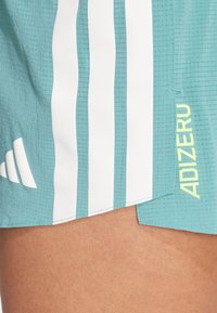 Akvamodri atletski šortsi iz teksturiranega blaga z belimi črtami in neon rumenim logotipom "ADIZERO" na strani.