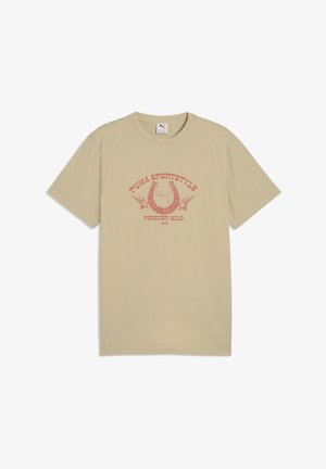 T-shirt beige à manches courtes avec un graphisme rouge de fer à cheval et d'étoile, texte « Puma Sportstyle Forever Wild 1948 » centré sur le devant.