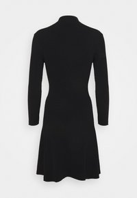 Robe noire en maille côtelée avec manches longues et col montant, cintrée à la taille et évasée légèrement à l'ourlet.