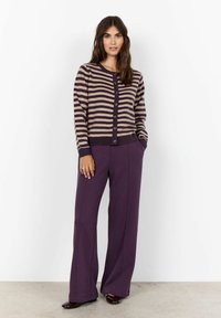 Striped cardigan in beige and dark purple, with a button front and ribbed cuffs, paired with high-waisted purple wide-leg trousers.