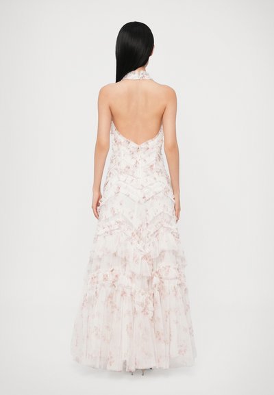 Rochie lungă, fără spate, din tul roz pal, cu un design cu volane și modele florale. Rochia are gât halter și o siluetă fluidă.