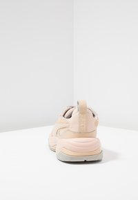 Baskets épaisses en cuir rose pâle et crème avec des accents en maille, col rembourré et un détail de logo au talon. Semelle extérieure en caoutchouc.