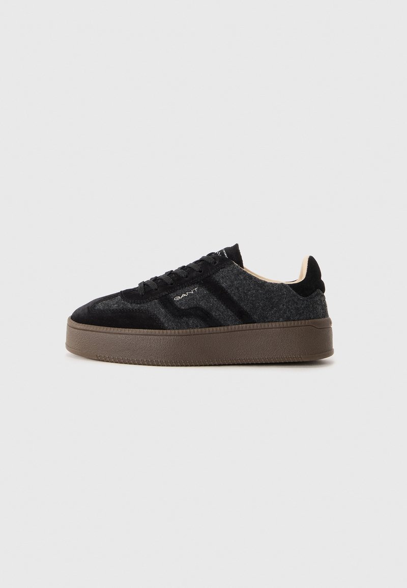 Baskets basses gris foncé et noir avec semelle marron texturée, fermeture à lacets à l'avant et logo de la marque sur le côté et la languette.