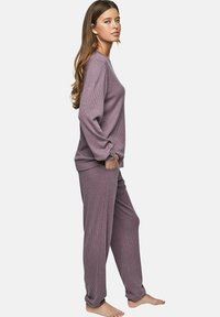 Mauve ribbel loungewear set met lange mouwen, losse broeken en zijzakken, met een relaxte pasvorm en een zachte textuur.