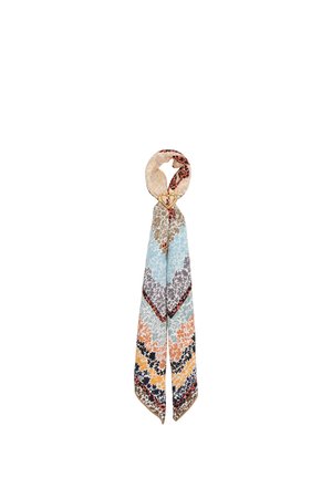Long silk scarf with multicolor floral patterns, looped through a gold heart-shaped ring on a white background.