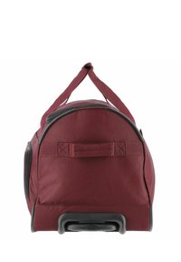 Maroon rolling duffel bag with a rounded shape, synthetic fabric, top carry handle, and black plastic wheels at the base. Zipper closure detail.