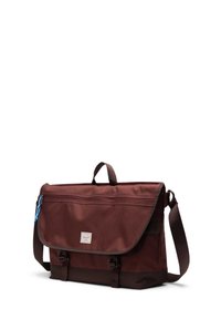 Brun stof messenger taske med klap, to spænder, sidehåndtag og justerbar rem. Har en blå lynlåstræk og logo på forsiden.