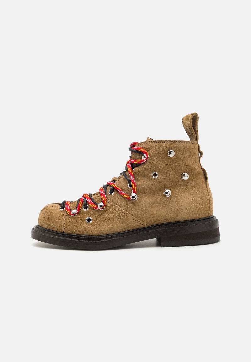 Kergedest nahk kingad punaste ja kollaste punutud paeltega, metallist silmadega ja lühikese musta kummitaldaga. Tagaküljel on tõmbeaas.