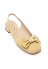 Žute balerinke od antilopa s remenčićem imaju zaobljeni vrh i veliki mašnu na prednjem dijelu. Potplat je nizak i četvrtastog oblika.