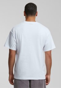 Hvid kortærmet t-shirt med rund hals, lavet af bomuldsstof, med en afslappet pasform og glat tekstur.
