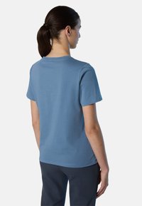 Maglietta azzurra chiara a maniche corte in tessuto morbido, con scollo rotondo e vestibilità rilassata. Design minimale, senza motivi o dettagli visibili.