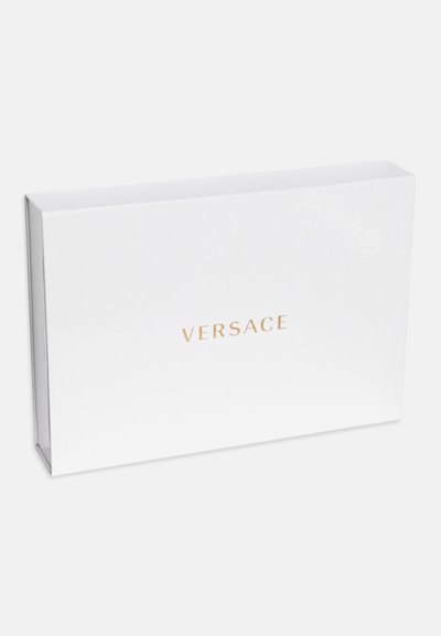 Boîte rectangulaire blanche avec une finition brillante, arborant le texte doré en relief "VERSACE" centré sur le devant. Design minimaliste.