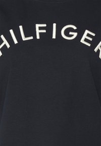 Námořnický bavlněný svetr se vyšitým textem "HILFIGER" bílou barvou na hrudi, s klasickým kulatým výstřihem.