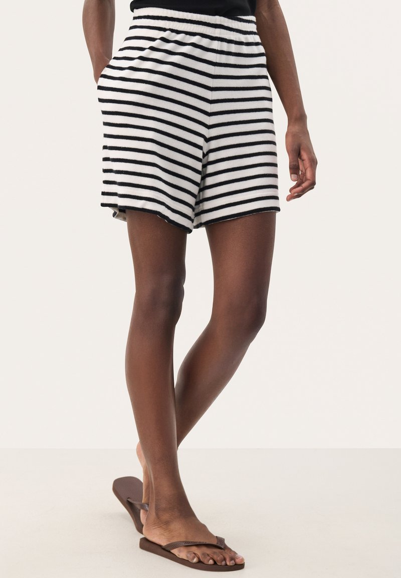 Black and white striped shorts with an elastic waistband, side pockets, and a relaxed fit, paired with brown flip-flops.