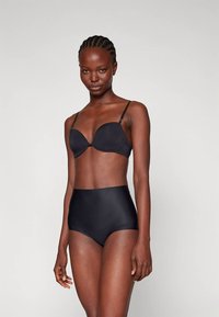 Sutiã preto com copas moldadas e alças ajustáveis, combinado com cuecas pretas de cintura alta. Textura lisa, design sem costuras.